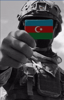 a soldier holds up a card with the flag of azerbaijan