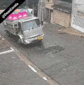 a mantle truck is driving down a street in front of a building