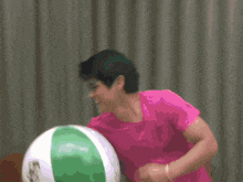 a woman in a pink shirt is standing in front of a sign that says c2