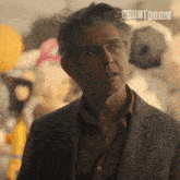a man in a suit stands in front of balloons with the word countdown on the bottom