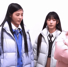 two girls standing next to each other with one wearing a blue shirt and tie