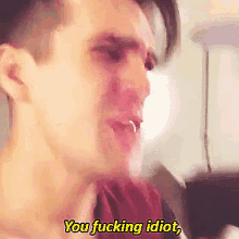 a close up of a man 's face with the words " you fucking idiot " above him