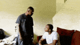 two men are standing next to each other in a living room talking