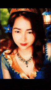 a woman with a blue flower in her hair is wearing a crown