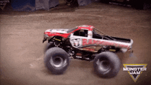 a monster jam truck is driving on a dirt track