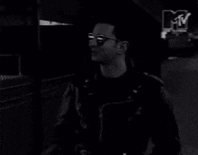 two men are laughing in a black and white photo with a mtv logo in the background