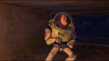buzz lightyear from toy story is sitting on the floor in a dark room .