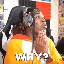 a man wearing headphones is asking why while sitting in a chair .