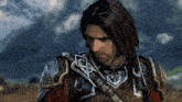 a man with long hair is wearing armor and looking down