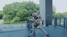 a person in a robot costume is standing in front of a building with trees in the background