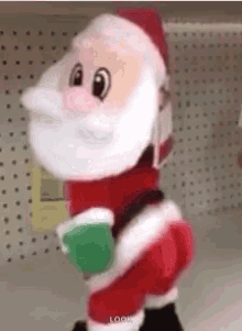 a stuffed santa claus is standing in a store holding a cup of coffee .