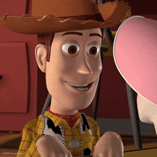 woody from toy story is smiling and wearing a sheriff 's uniform
