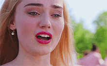 a close up of a woman 's face with her mouth open and red lips .