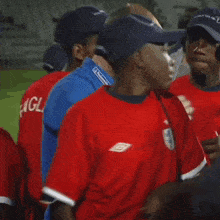 a man wearing a red shirt that says " gla " on it