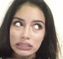 a close up of a woman making a funny face with her eyes closed .