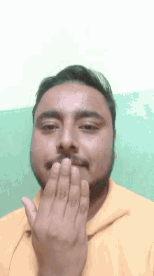 a man with a beard covering his mouth with his hands