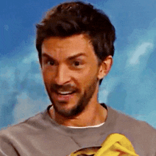a man with a beard is wearing a grey shirt