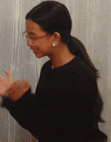 a young girl wearing glasses and a black sweater