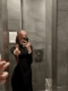a woman is taking a picture of herself in a mirror .