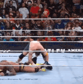 a wrestling match is going on in front of a crowd with a sign that says ' america ' on it