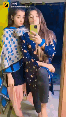 two girls are taking a picture of themselves in front of a mirror ..