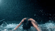a woman is laying on her back in the water with her arms outstretched