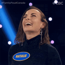 a woman wearing a name tag that says natalie laughs