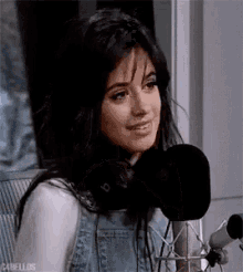 a woman is sitting in front of a microphone .
