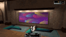 a video game screen shows a person laying on the floor in front of a large painting with the name brendgoated on it