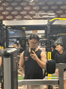a man taking a picture of himself in a gym with a sign that says ' ymca club ' on it