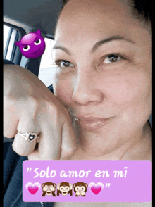 a woman with a ring on her finger is sitting in a car next to a sign that says solo amor en mi