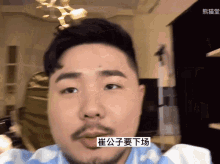 a man with a beard is wearing a blue and white striped shirt with chinese writing on it