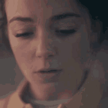 a close up of a woman 's face with her eyes closed .