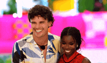 a man and a woman are standing next to each other smiling