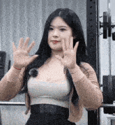 a woman waving her hands in front of a barbell