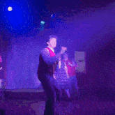 a group of people are dancing on a stage in front of a sign that says ' a ' on it