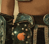 a close up of a person wearing a belt with a seashell and pearls on it
