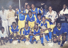 a group of soccer players posing for a photo with a man wearing a shirt that says m/r