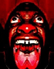 a close up of a man 's face with his mouth open and tongue sticking out .