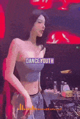 a woman in a crop top is dancing in front of a dance youth sign .