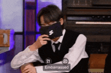 a man in a suit and tie is wearing a black mask .