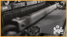 a machine is making a piece of fabric with the letters ug on it