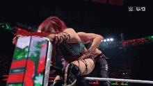 two women are wrestling in a ring with the letters w on the bottom right