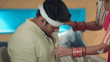 a man has a bandage on his head and a woman is putting a ring on his finger