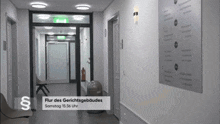 a long hallway with a sign that says flur des gerichtsgebäudes