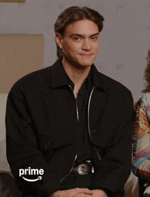 a man is wearing a black jacket with the word prime on the sleeve