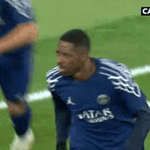 a soccer player wearing a blue shirt that says qatar airways