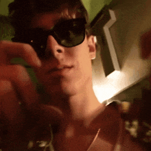 a man wearing sunglasses looks at the camera