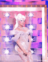 a drag queen in a white dress is dancing on stage