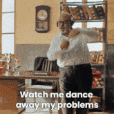 a man wearing headphones is dancing in an office with the words watch me dance away my problems below him